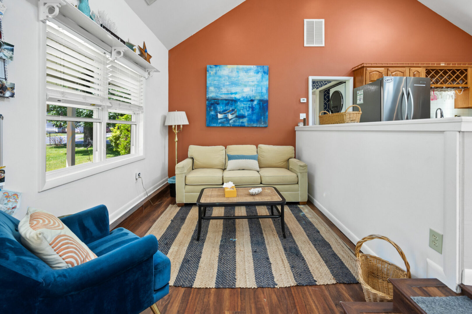 Cozy living room with blue accents and striped rug.