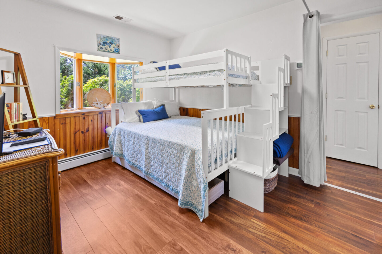 Cozy bedroom with bunk beds and natural light from a wooden window.
