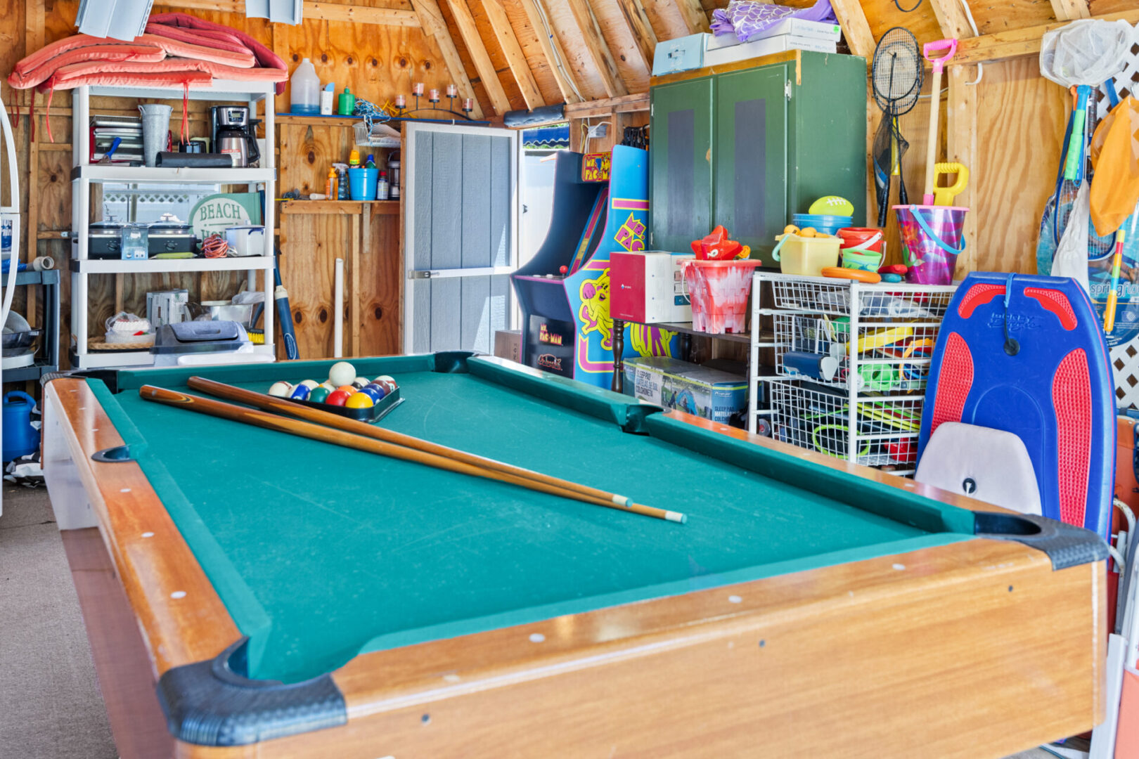A vibrant pool table in a colorful, toy-filled game room.