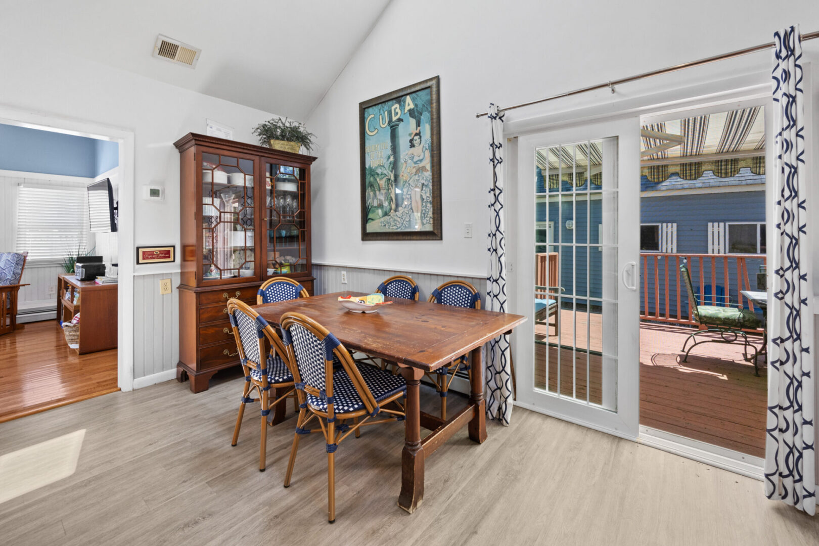 Cozy dining area with wooden table and chairs by glass doors.