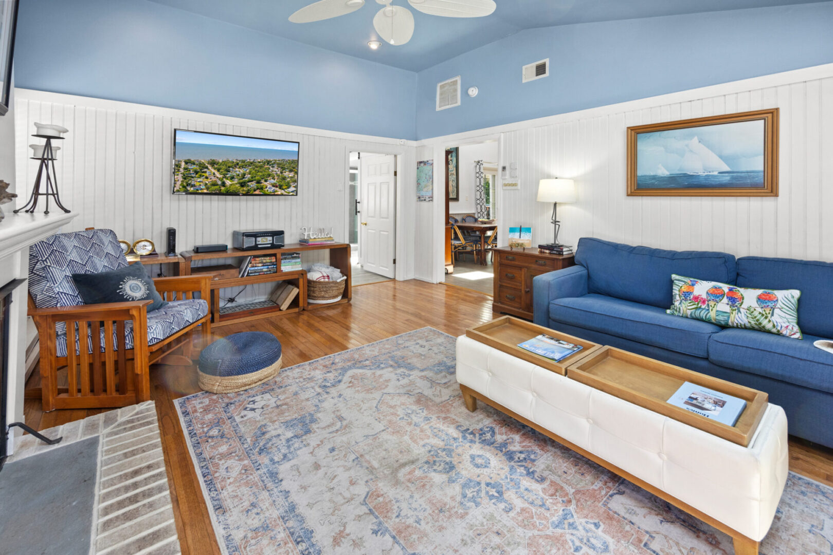 Bright living room with blue sofa and wooden floors.