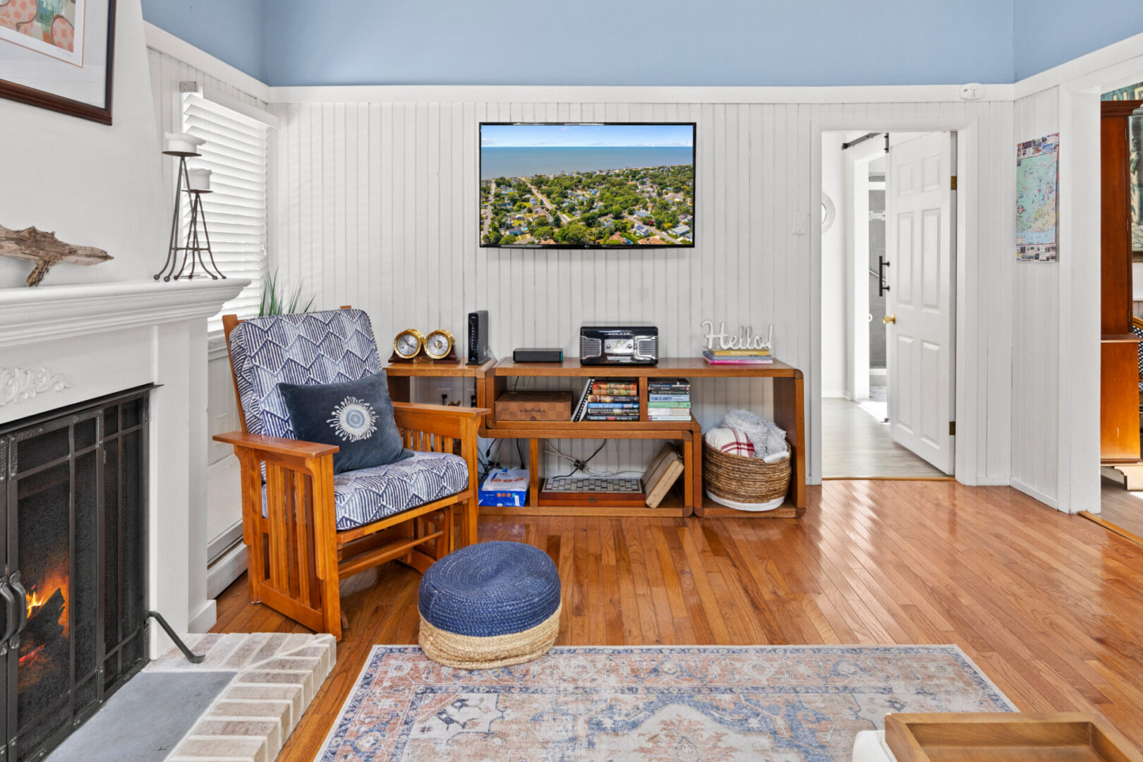 Cozy reading nook with wooden furniture and a landscape photo on the wall.