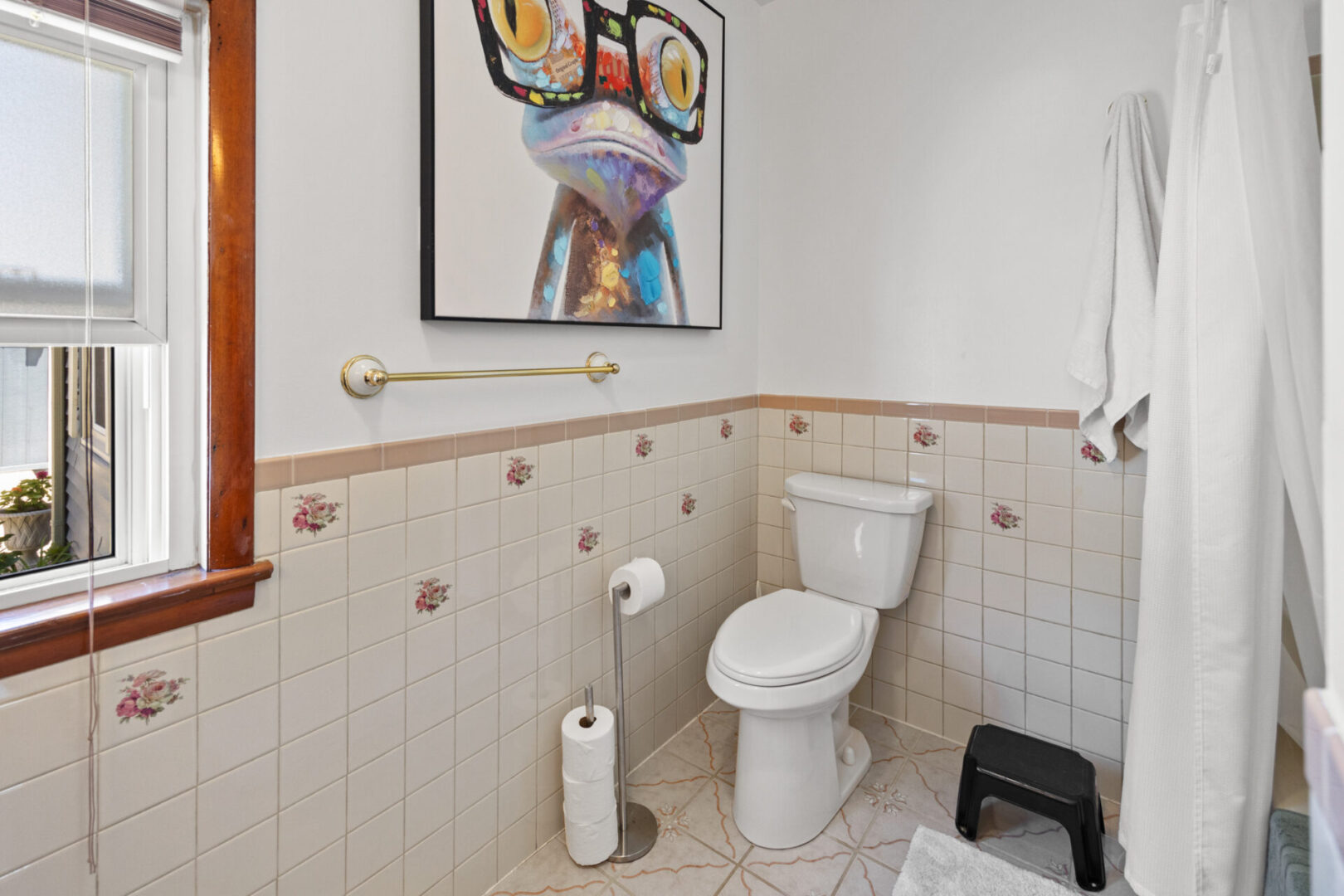 Clean bathroom with unique duck painting and white fixtures.