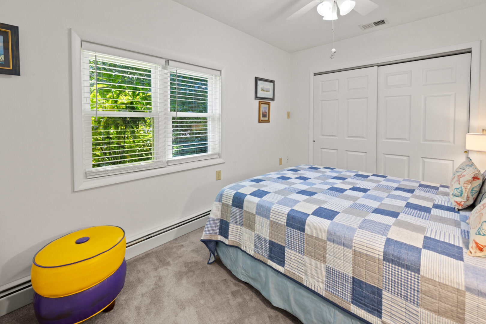 Cozy bedroom with a checkered quilt and bright window.